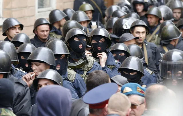 Ukrainian Interior Ministry security forces, blocked by pro-Russian activists, gather outside the regional government headquarters in Luhansk, eastern Ukraine, April 29, 2014. Hundreds of pro-Russian separatists stormed the regional government headquarters in Ukraine's eastern city of Luhansk on Tuesday, gaining access by breaking windows and facing no resistance from police. (Photo by Vasily Fedosenko/Reuters)