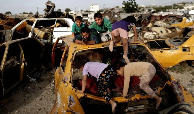 Palestinian children play amidst wrecked cars in an impoverished area in the southern Gaza Strip city of Khan Yunis, on May 9, 2016. (Photo by Thomas Coex/AFP Photo)
