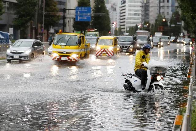 A man rides a moped through a flooded street due to a typhoon in Tokyo Monday September 9, 2019. (Photo by Kyodo News via AP Photo)