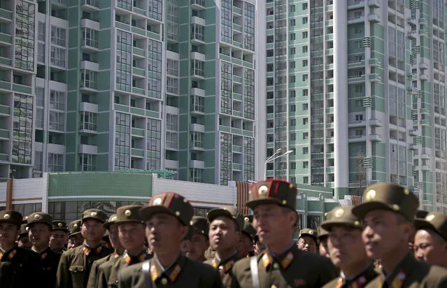 Newly completed high-rise buildings of Ryomyong residential area, a collection of more than a dozen apartment buildings are seen in the background while military soldiers walk in the foreground on Thursday, April 13, 2017, in Pyongyang, North Korea. (Photo by Wong Maye-E/AP Photo)