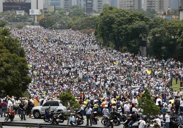 Anti-government protesters march along a highway in Caracas, Venezuela, Wednesday, April 19, 2017. (Photo by Ariana Cubillos/AP Photo)