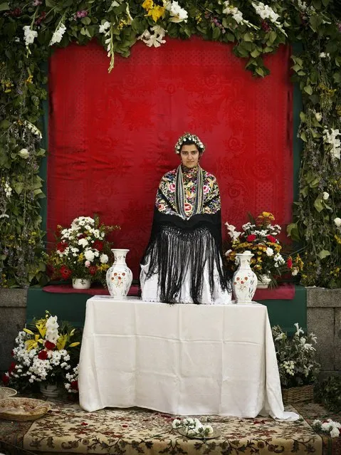 In this photo taken on Sunday, May 11, 2014, a “Maya” girl sits on an altar during the traditional celebration of “Las Mayas” on a street, in central Madrid, Spain. (Photo by Daniel Ochoa de Olza/AP Photo)
