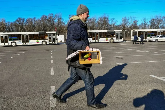 A man carries a bird after fleeing Mariupol amid Russia's ongoing attack on Ukraine, in Zaporizhzhia, Ukraine on March 19, 2022. (Photo by Reuters/Stringer)
