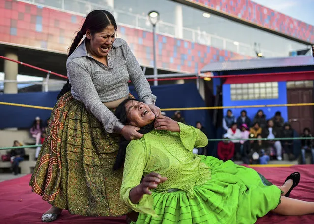 Bolivian wrestler Ana Luisa Yujra (L), aka “Jhenifer Two Faces” and Lidia Flores, aka “Dina, The Queen of the Ring”, both members of the Fighting Cholitas, fight at Sharks of the Ring wrestling club in El Alto, Bolivia, on November 24, 2019. After a fortnight hiatus due to anti-government protests and blockades, the Fighting Cholitas are back in the ring. The unrest was triggered by the disputed October 20 election, which Evo Morales claimed to have won and opposition groups said was rigged. (Photo by Ronaldo Schemidt/AFP Photo)