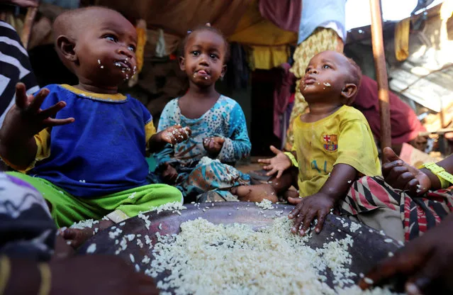 Internally displaced Somali children eat boiled rice outside their family's makeshift shelter at the Al-cadaala camp in Somalia's capital Mogadishu March 6, 2017. (Photo by Feisal Omar/Reuters)