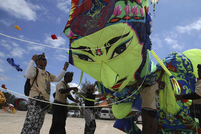 Participants prepare a kite during Denpasar international kite festival in Sanur, Bali, Indonesia Friday, August 16, 2024. (Photo by Firdia Lisnawati/AP Photo)