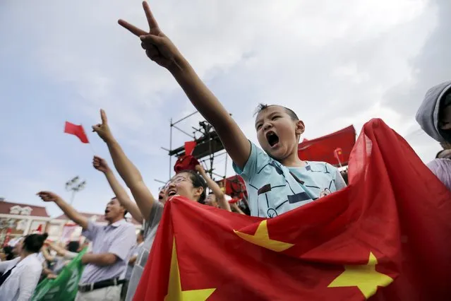 A boy and his mother holding Chinese flag celebrate after Beijing was chosen to host the 2022 Winter Olympics at a square in Chongli county of Zhangjiakou, jointly bidding to host the 2022 Winter Olympic Games with capital Beijing, July 31, 2015. (Photo by Jason Lee/Reuters)