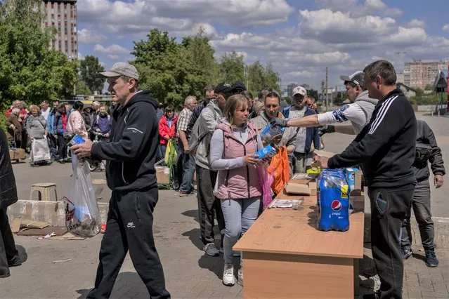 People queue to receive food donations in Kharkiv, eastern Ukraine, Thursday, May 19, 2022. (Photo by Bernat Armangue/AP Photo)