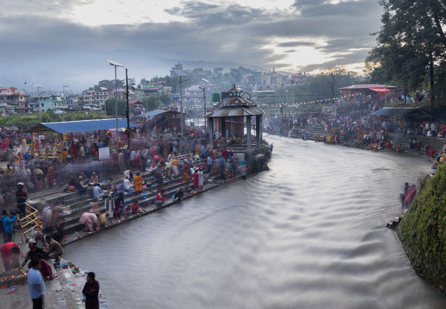 Nepalese devotees gather at the Bagmati River to commemorate their deceased fathers at the sacred shrine of Lord Shiva, Gokarneswor Shrine, near Kathmandu, Nepal, 02 September 2024. On Father's Day, sons and daughters show their gratitude to their fathers, bringing them presents, sweets and fruits. Those who no longer have a father, traditionally visit Gokarneswor Shrine where they conduct puja and offer “Pinda” – food for the departed soul and pray for his eternal peace. (Photo by Narendra Shrestha/EPA/EFE)