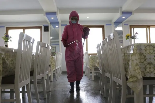An employees of Pyongyang Dental Hygiene Products Factory disinfects the floor of a dining room as the state increased measures to stop the spread of illness in Pyongyang, North Korea Monday, May 16, 2022. (Photo by Cha Song Ho/AP Photo)