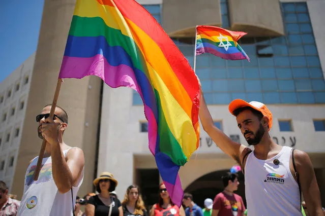 Revellers observe a minute's silence in memory of the victims of the Pulse gay nightclub shooting in Orlando, Florida, during a gay pride parade in the southern city of Ashdod, Israel, June 17, 2016. (Photo by Amir Cohen/Reuters)