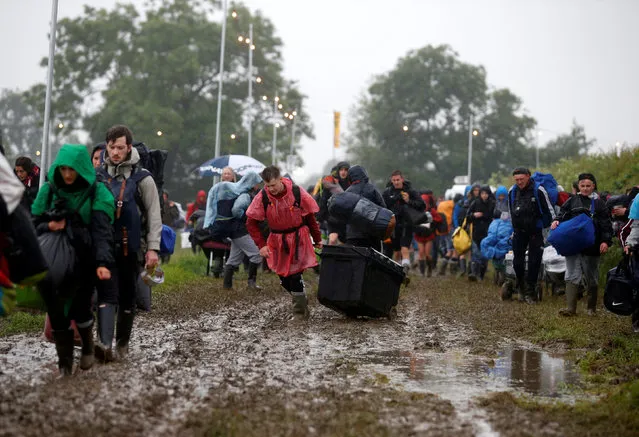 Revellers carry their belongings as they arrive at Worthy Farm in Somerset for the Glastonbury Festival, Britain, June 22, 2016. (Photo by Stoyan Nenov/Reuters)