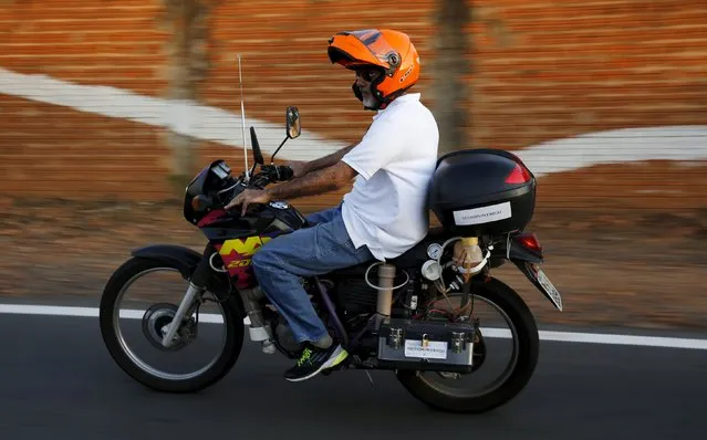 Ricardo Azevedo rides his Honda NX 200 motorbike, which he converted to be powered by water, in Salto, northwest of Sao Paulo, Brazil, August 6, 2015. The Sao Paulo civil servant built the motorbike which can cover up to 500 kilometres (311 miles) fueled by just one liter of water. Dubbed "Moto Power H2O", the bike is powered by a process of electrolysis by which the water molecule is broken down into its constituent elements. (Photo by Nacho Doce/Reuters)