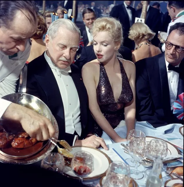 A waiter serves food to American finacier Winthrop Aldridge (1885 – 1974), who sits beside married couple, actress Marilyn Monroe (born Norma Jeane Mortenson, 1926 – 1962) and playwright Arthur Miller (1915 – 2005), during the “April in Paris Ball” at the Waldorf Astoria, New York, New York, April 11, 1957. (Photo by Peter Stackpole/The LIFE Picture Collection/Getty Images)
