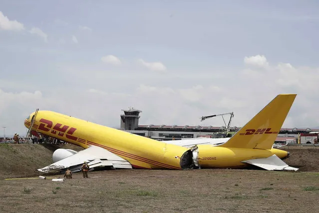 A view of a DHL courier company plane (Boeing 757-27A tail number: HP-2010DAE) that broke in two after going off the runway due to a hydraulic problem, at the Juan Santamaria airport, in San Jose, Costa Rica, 07 April 2022. The plane took off from the Costa Rican airport bound for Guatemala, but upon detecting the hydraulic problem the pilots decided to return, the plane landed and after a few seconds of rolling smoke coming out of its tires, the plane skids, goes off the runway and is split in two. (Photo by Jeffrey Arguedas/EPA/EFE)