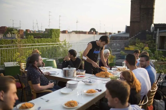 Migrants and Germans of the “Sharehaus Refugio” community have dinner on their roof garden in Berlin, Germany August 19, 2015. (Photo by Axel Schmidt/Reuters)