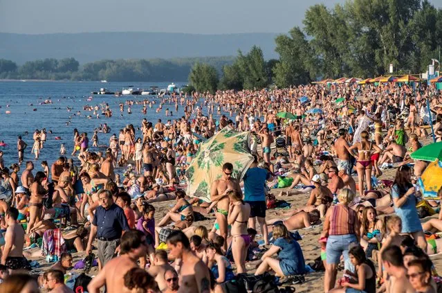 People sunbathe at a beach on the Volga river in downtown Samara on August 23, 2017. Samara will host several football matches as part of the FIFA World Cup 2018 that will be held from June 14 to July 15, 2018 in Russia. (Photo by Mladen Antonov/AFP Photo)