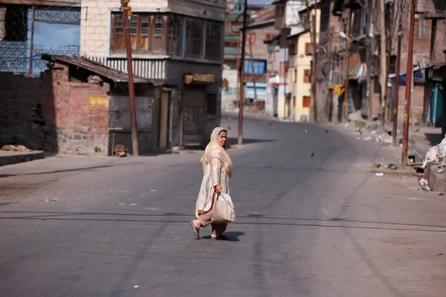 A woman crosses a deserted road during a curfew in Srinagar July 12, 2016. (Photo by Danish Ismail/Reuters)