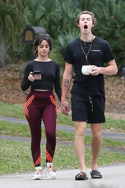 Quarantine couple Camila Cabello and Shawn Mendes got a dose of Vitamin D with their caffeine in Miami this morning, March 26, 2020 during a walk around their neighborhood. The adorable couple walked hand in hand chatting together as they stepped out for a bit of healthy exercise. Camila who recently announced that she would be postponing her tour dressed up her  leggings and crop top with a large pair of hoops while Shawn sported black shorts, a ripped t-shirt, slides and a set of Buddhist prayer beads around his neck. (Photo by Backgrid USA)