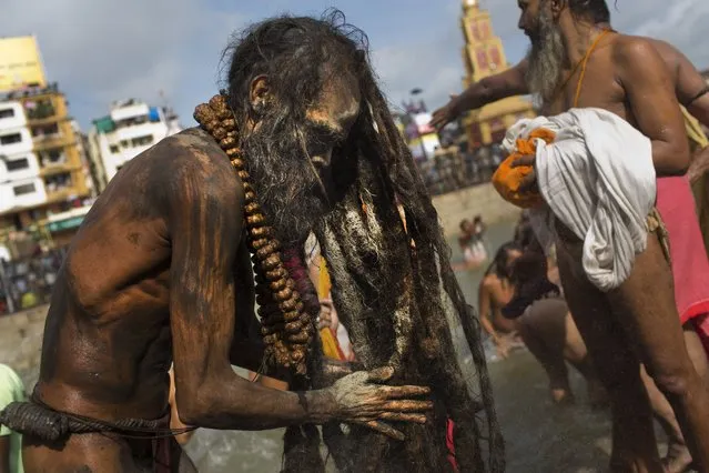 An Indian Sadhu, or Hindu holy man, rubs ash on his hair after a bath in the Godavari River during Kumbh Mela, or Pitcher Festival, in Nasik, India, Saturday, August 29, 2015. (Photo by Bernat Armangue/AP Photo)