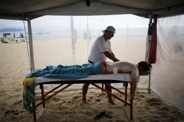 A tourist receives a massage on Copacabana beach in Rio de Janeiro, Brazil, June 4, 2016. (Photo by Nacho Doce/Reuters)