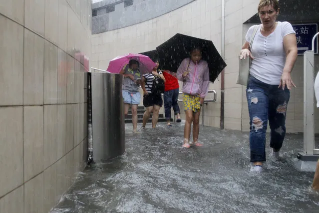 People walk in a flooded underpass during a heavy rainfall in Beijing, China, July 20, 2016. (Photo by Reuters/China Daily)