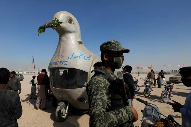 A policeman stands next to an auto rickshaw (tuk tuk), modified by an enthusiast to resemble a dove with an olive branch, during the 15th edition of the Cholistan Desert Rally 2020, in Cholistan Desert, Pakistan on February 16, 2020. (Photo by Akhtar Soomro/Reuters)
