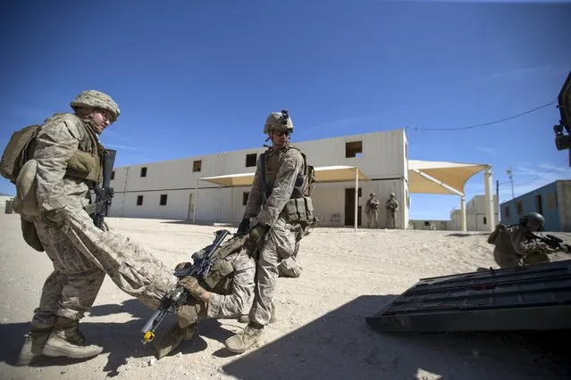 U.S. Marines from Fox Company, 2nd Battalion 1st Marines, 13th Marine Expeditionary Unit evacuate a "killed in action" during a non-live fire Military Operations in Urban Terrain (MOUT) training at US Marine Corps: Marines Air Ground Combat Center in Twentynine Palms, California September 1, 2015. (Photo by Mario Anzuoni/Reuters)