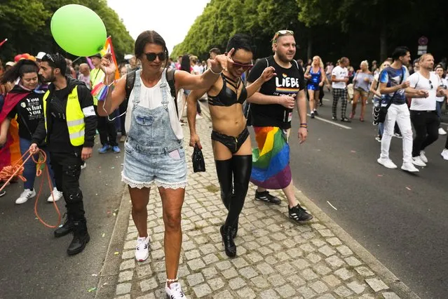 Revelers dance as take part in the annual pride march in Berlin, Germany, Saturday, July 23, 2022. Draped in rainbow flags, around 150,000 people were marching for LGBTQ rights at Berlin's annual Christopher Street Day celebration. Berlin police gave the crowd estimate on Saturday afternoon but said the number could grow into the evening. (Photo by Markus Schreiber/AP Photo)