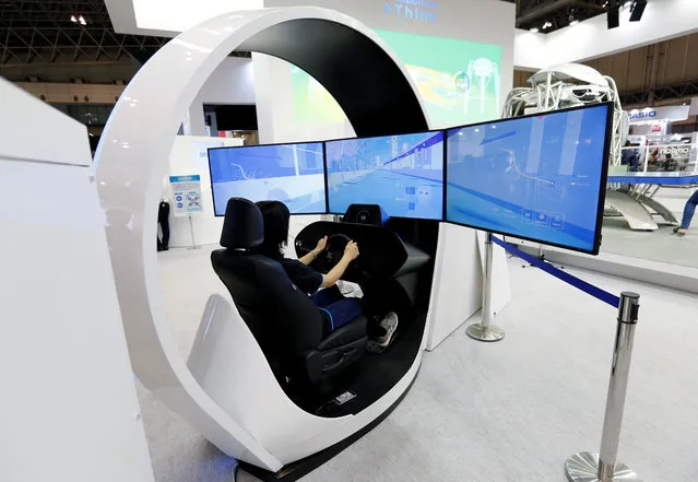 A woman demonstrates Omron Corp's “Onboard Driving Monitoring Sensor”, which senses the driver's alertness at CEATEC (Combined Exhibition of Advanced Technologies) JAPAN 2017 at the Makuhari Messe in Chiba, Japan, October 2, 2017. (Photo by Toru Hanai/Reuters)
