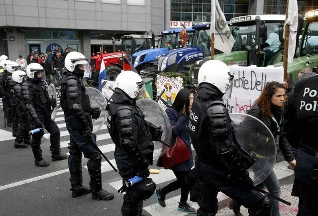 Belgian riot police officers stand guard as farmers and dairy farmers from all over Europe take part in a demonstration outside an European Union farm ministers emergency meeting at the EU Council headquarters in Brussels, Belgium, September 7, 2015. (Photo by Jacky Naegelen/Reuters)