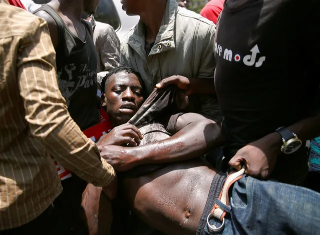A supporter of the opposition National Super Alliance (NASA) coalition, who was knocked by a car and got injured, is assisted during a protest calling for the sacking of election board officials involved in August's cancelled presidential vote, in Nairobi, Kenya on October 9, 2017. (Photo by Thomas Mukoya/Reuters)