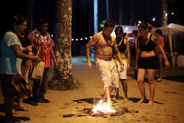 Surinamese Caribe and Arawak natives try to put out a fire to set the spirit free during the Epekodono (hair cutting) mourning ceremony, ahead of the celebrations of the UN's International Day of Indigenous People in the Palm Garden in Paramaribo, Suriname, August 8, 2016. (Photo by Ranu Abhelakh/Reuters)