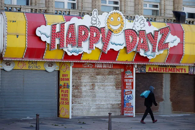 A man walks past closed shops near Blackpool beach following the outbreak of the coronavirus disease (COVID-19), Blackpool, Britain, May 25, 2020. (Photo by Phil Noble/Reuters)