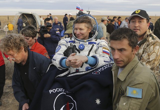 Ground personnel carry Russian cosmonaut Gennady Padalka after he landed near the town of Dzhezkazgan (Zhezkazgan), Kazakhstan, September 12, 2015. (Photo by Yuri Kochetkov/Reuters)