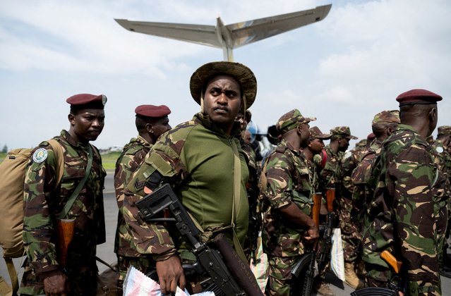 Members of the Kenya Defence Forces (KDF), part of the East Africa Community Regional Force (EACRF) troops, gather near their plane as they withdraw their deployment as part of a regional military operation targeting rebels, after the Democratic Republic of Congo did not renew its mandate to help fight M23 rebels, at the airport in Goma, North Kivu province, Democratic Republic of Congo on December 2, 2023. (Photo by Arlette Bashizi/Reuters)