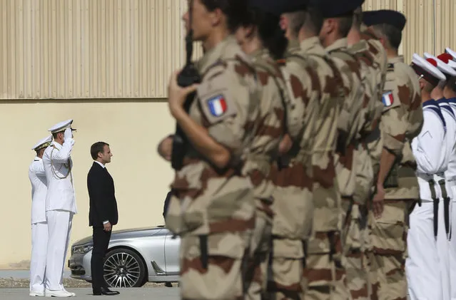 French President Emmanuel Macron views the French honor guard at the naval base during his second day of visit in Abu Dhabi, United Arab Emirates, Thursday, November 9, 2017. (Photo by Kamran Jebreili/AP Photo)