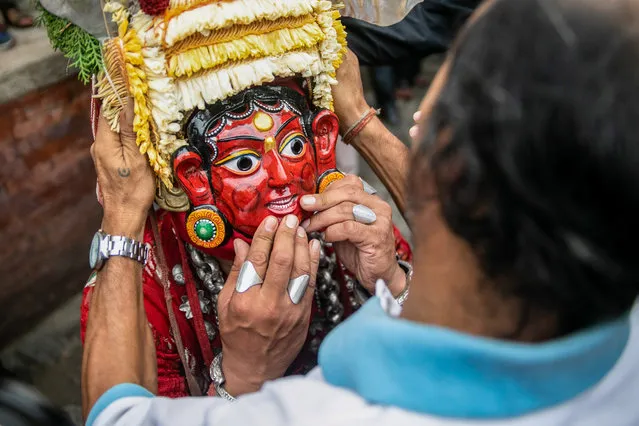 A traditional Nepali masked dancer adjusts his mask after performing on the first day of the Indra Jatra festival at Basantapur Durbar Square in Kathmandu on September 7, 2022. The annual festival, named after Indra, the god of rain and heaven, is celebrated by worshipping, rejoicing, singing, dancing, and feasting in Kathmandu Valley to mark the end of the monsoon season. Indra, the living goddess Kumari and other deities are worshipped during the festival. (Photo by Prabin Ranabhat/SOPA Images/Rex Features/Shutterstock)