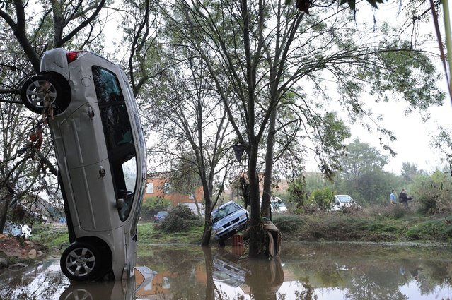 A picture taken on October 7, 2014 in Grabels near Montpellier shows a car in an upright position following the overnight flash floods due to heavy showers.  Floodwater streamed down roads and highways, engulfing cars as the Lez river burst its banks in the seaside capital of the Languedoc-Roussillon region after it was lashed by record-breaking downpours. (Photo by Sylvain Thomas/AFP Photo)
