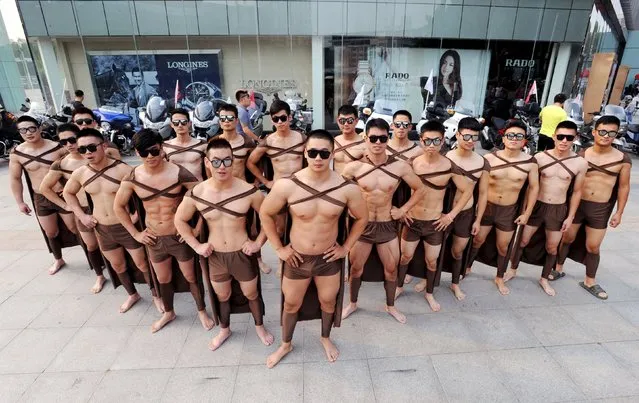 Male fitness instructors and students dressed as Spartan warriors pose during a celebration of the one-year anniversary of juice company Juicedaily in front of a shopping mall in Xuzhou, Jiangsu province, September 19, 2015. (Photo by Reuters/Stringer)