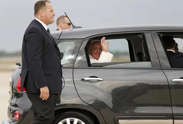 Pope Francis waves as he is driven away in a Fiat 500 model after arriving in the United States at Joint Base Andrews outside Washington September 22, 2015. (Photo by Jonathan Ernst/Reuters)