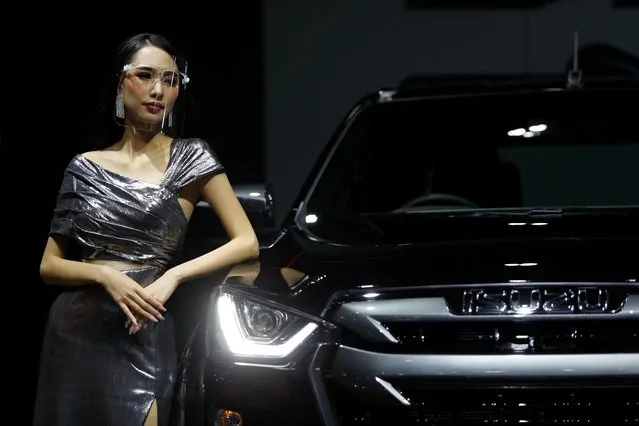 A model leans against a Isuzu vehicle during the media day of the 41st Bangkok International Motor Show after the Thai government eased measures to prevent the spread of the coronavirus disease (COVID-19) in Bangkok, Thailand on July 14, 2020. (Photo by Jorge Silva/Reuters)