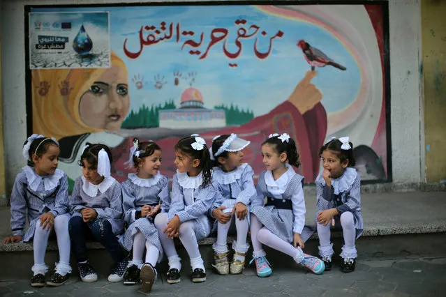 Palestinian schoolgirls sit in front of a mural on the first day of a new school year, at a United Nations-run school in Khan Younis in the southern Gaza Strip August 28, 2016. The mural reads, “Freedom of movement is my right”. (Photo by Ibraheem Abu Mustafa/Reuters)