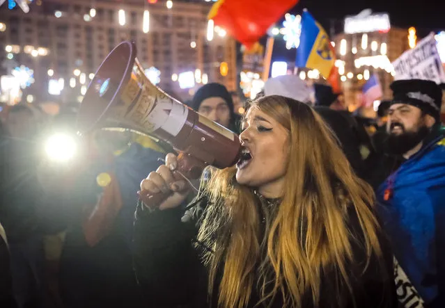 A girl shouts outside the government headquarters in Bucharest, Romania, Sunday, December 10, 2017. More than 10,000 people on Sunday participated in another round of protests against Romanian legislation that critics say would make it harder to punish high-level corruption. (Photo by Vadim Ghirda/AP Photo)