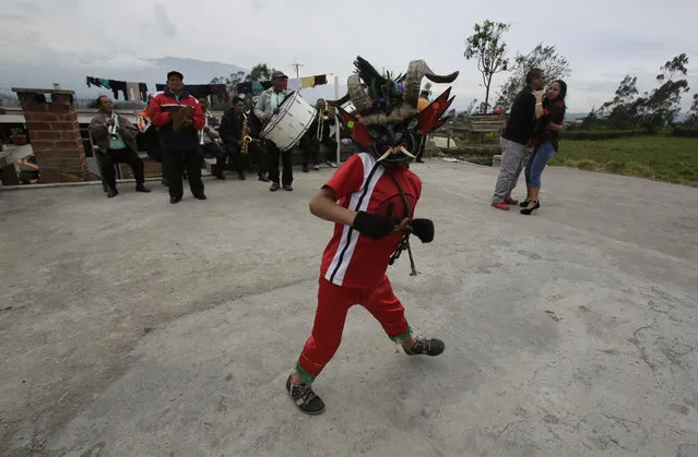 A man wearing a devil mask dances during the traditional New Year's festival known as “La Diablada”, in Pillaro, Ecuador, Friday, January 5, 2018. (Photo by Dolores Ochoa/AP Photo)