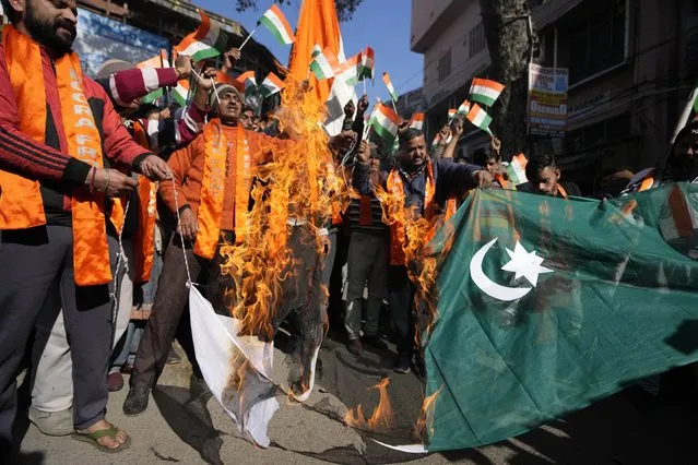 Activists of right wing Hindu groups Dogra Front and Shiv Sena, reacting to the militant attack in the southern Rajouri district of Indian-controlled Kashmir burn Pakistan flag during a protest in Jammu, India, Monday, January 2, 2023. Assailants sprayed bullets toward a row of civilian homes Sunday night, leaving at least four civilians dead and five others injured, police said Monday. (Photo by Channi Anand/AP Photo)