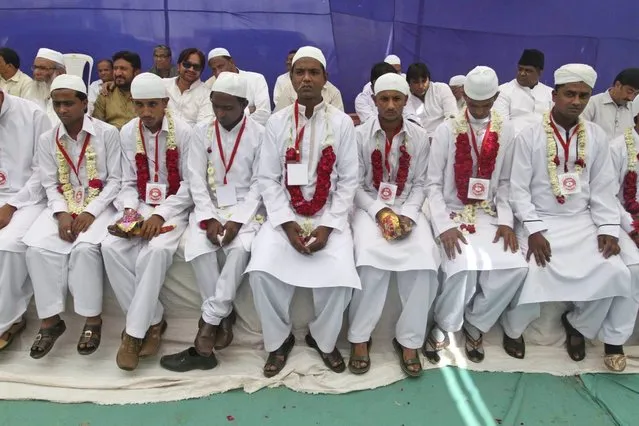 Indian grooms, front, sit during a mass marriage of 162 Muslim couples in Ahmadabad, India, Sunday, March 3, 2013. Mass marriages in India are organized by social organizations primarily to help the economically backward families who cannot afford the high ceremony costs as well as the customary dowry and expensive gifts that are still prevalent in many communities. (Photo by Ajit Solanki/AP Photo/LaPresse)