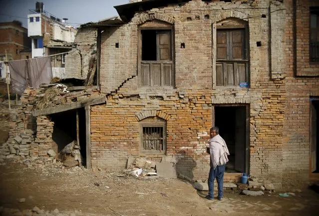 A man stands outside his house, which was damaged during last year's earthquake, in Bhaktapur, Nepal, January 29, 2016. (Photo by Navesh Chitrakar/Reuters)