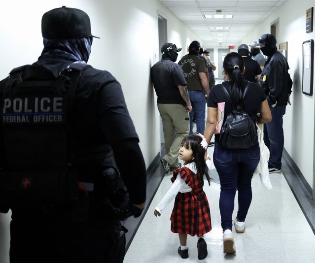 A woman and her child arrive at a hearing as federal agents patrol the hallways outside of a courtroom at New York Federal Plaza Immigration Court at the Jacob K. Javitz Federal Building in New York City on August 20, 2025. US President Donald Trump has made deporting undocumented immigrants a key priority for his second term, after successfully campaigning against an alleged “invasion” by criminals. (Photo by Charly Triballeau/AFP Photo)