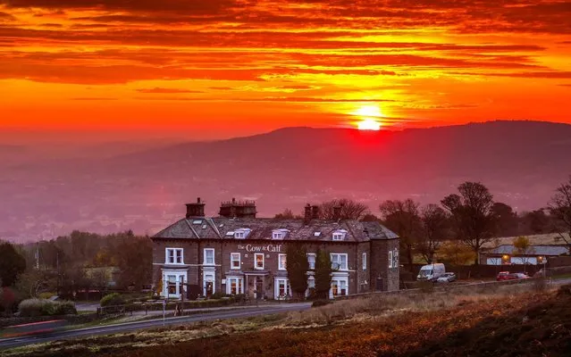 The sky glows red as the sun rises this morning over the Cow & Calf pub on Ilkley moor in Yorkshire, United Kingdom on October 19, 2020 as the UK expects heavy rain and gales this week. (Photo by Andrew McCaren/LNP)